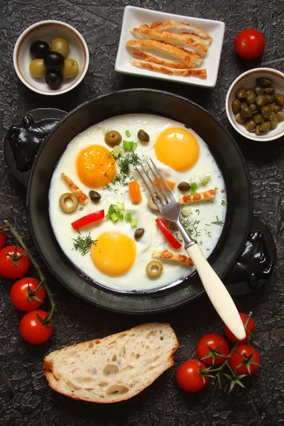 Жареные яйца в чугунной кастрюле с перцем, помидорами, каперсами, он — стоковое фото