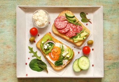 Tost krem peynir, ricotta, otlar, sosis, avokado, yumurta ile, 
