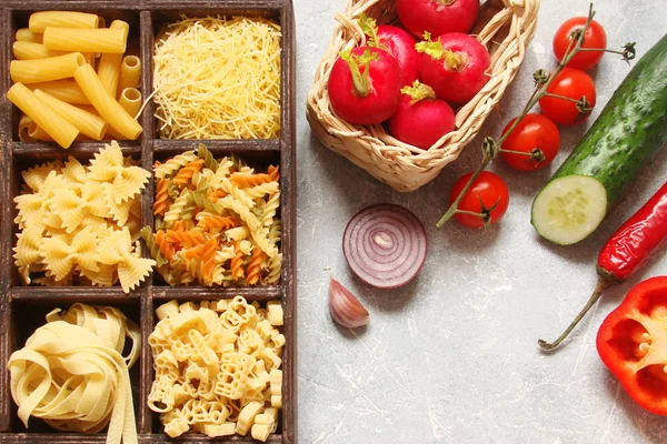 Pasta with vegetables, spices and herbs in wooden cells