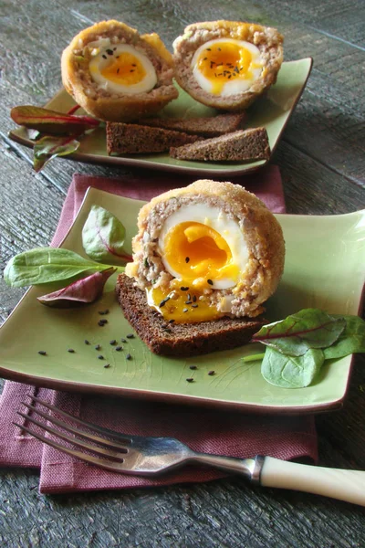 Scotch eggs with herbs on the green bowl
