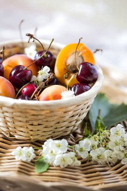 Taze meyve kayısı ve hasır sepet içinde kiraz