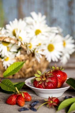 bir ahşap tahta üzerinde beyaz bir fincan taze çilek
