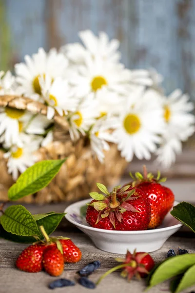 bir ahşap tahta üzerinde beyaz bir fincan taze çilek