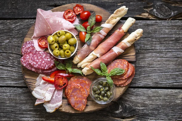 Comida italiana, prosciutto, grissini, salchicha ahumada, jamón, aceitunas , — Foto de Stock
