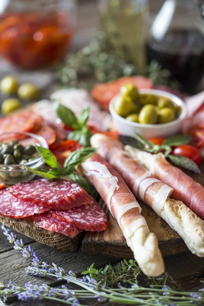 Comida italiana, prosciutto, grissini, salchicha ahumada, jamón, aceitunas , — Foto de Stock