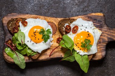 Kızarmış yumurtalı sandviç ekmeğin yeşillikleri ile