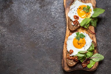 Kızarmış yumurtalı sandviç ekmeğin yeşillikleri ile