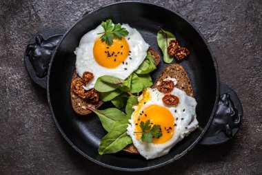 Kızarmış yumurtalı sandviç ekmeğin yeşillikleri ile