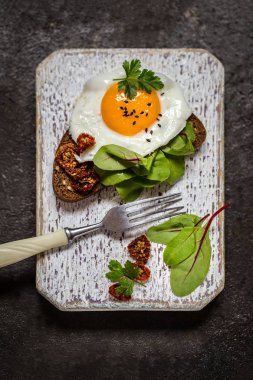 Kızarmış yumurtalı sandviç ekmeğin yeşillikleri ile