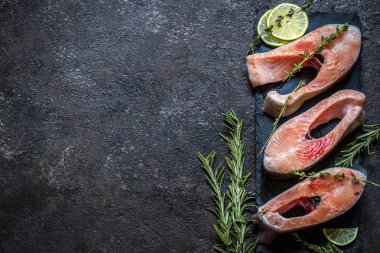 Balık alabalık, karanlık bir arka plan üzerinde taze yeşillik