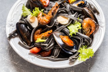 Siyah makarna, midye, karides ve sebze, yumurta ile deniz ürünleri