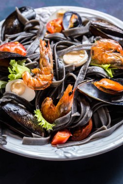 Siyah makarna, midye, karides ve sebze, yumurta ile deniz ürünleri