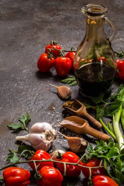 domates, yeşil soğan, tuz, baharat, karanlık bir arka plan üzerinde yemek pişirmek için otlar