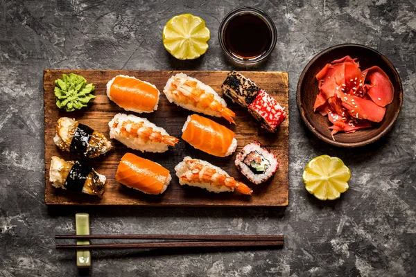 suşi ve suşi rulo, suşi nigiri koyu arka plan, hardal wasabi ve zencefil taş plaka üzerinde