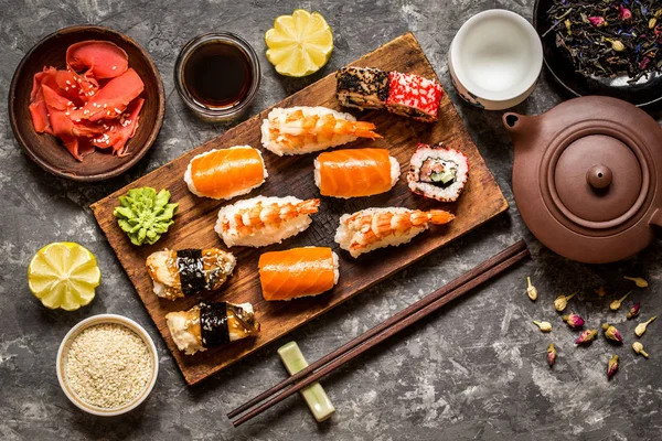 suşi ve suşi rulo, suşi nigiri koyu arka plan, hardal wasabi ve zencefil taş plaka üzerinde