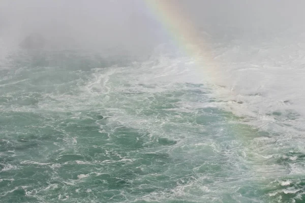 Vacker bild med vattnet nära fantastiska Niagarafallen med en regnbåge — Stockfoto