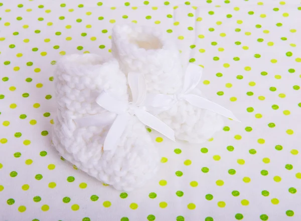 Gebreide baby sokken op de weefsel achtergrond — Stockfoto