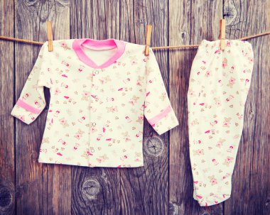 Bebek ürünler clothesline üzerinde asılı. Bebek bluz ve pantolon kaydırıcıları halata clothespin