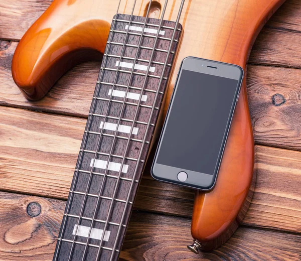 빈티지 베이스 기타에 스마트폰 모형. — 스톡 사진
