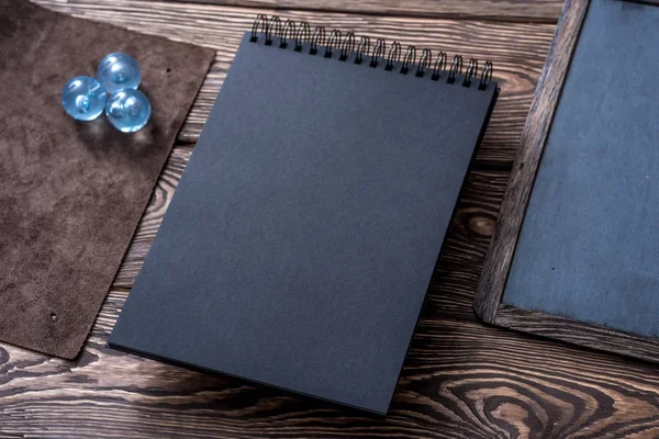 Zwarte schetsboek op houten tafel — Stockfoto