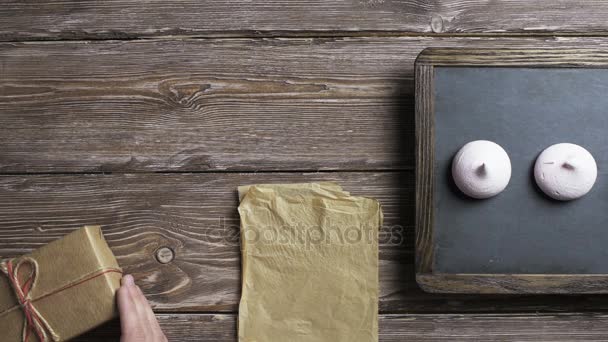 Man puts gift boxes one by one to wooden desktop — Stock Video