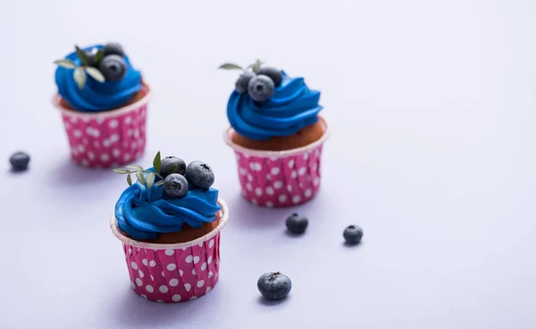 Three cupcakes with blue cream — Stock Photo, Image