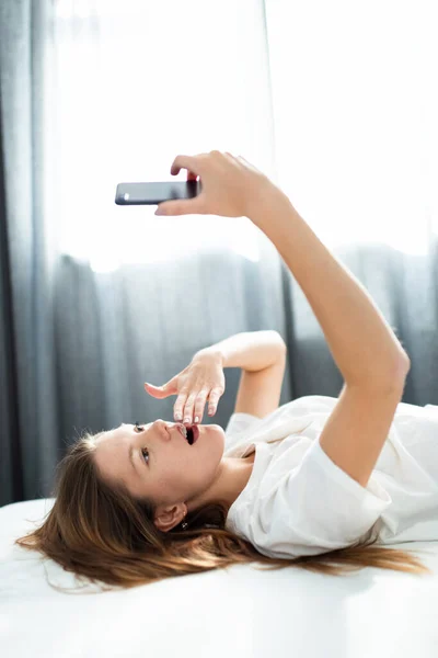 Adorabile adolescente sorpreso con uno smartphone . — Foto Stock