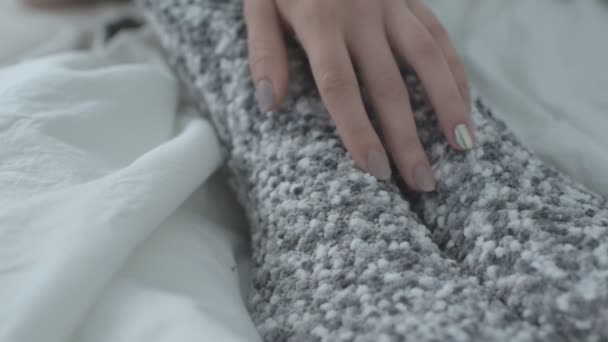 Een vrouw met warme sokken leidt haar hand langs haar been. Sluiten. — Stockvideo