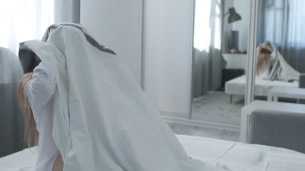 Jolie fille jette une couverture et sourire à la caméra — Video