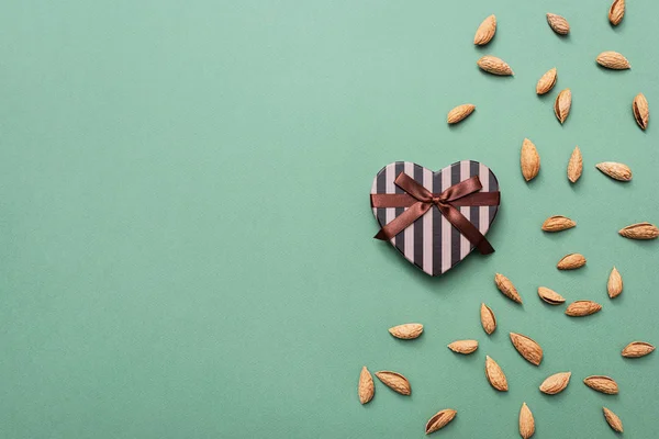 Hjärtformad presentask bland mandlar — Stockfoto