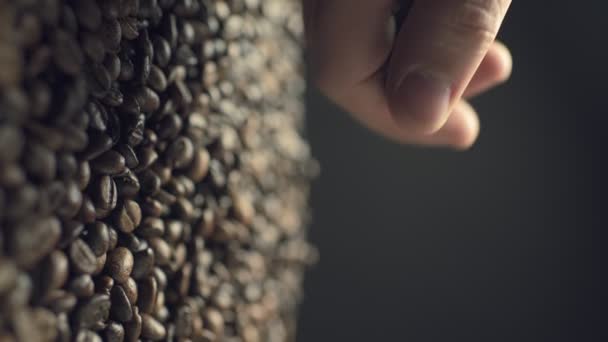 Closeup of coffee beans scatter out of males hand in slow motion — Stockvideo