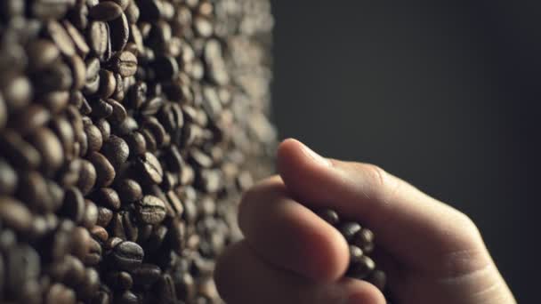 Closeup of coffee beans scatter out of males hand in slow motion — Stockvideo