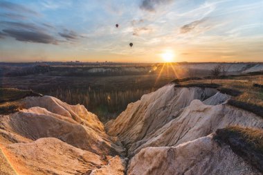 Gün batımında kanyon, kayalar, uçurum, uçurum, gökyüzünde balonlar. Havada yüzme, havada yüzme