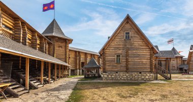 Ahşap evler. Antik şehrin yeniden inşası. Kütük evler. Eski şehir. Tahta kale. Sokaklar taşlarla döşenmiş. Antik Rus yerleşkesi. Köylü evleri. Slav köyü. Kalenin tahta duvarları. Kulelerde bayraklar.