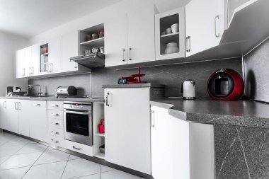 Evde klasik tarzda mutfak, mermer teçhizatlarla bembeyaz dekore edilmiş ve paslanmaz çelikten veya koyu kırmızı renkte sayısız aksesuar ve aletlerle donatılmış. Zemin beyaz kare karolarla kaplı..