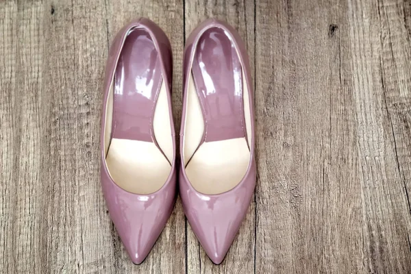 Pointy patent pumps in old pink color on wooden floor — Stock Photo, Image