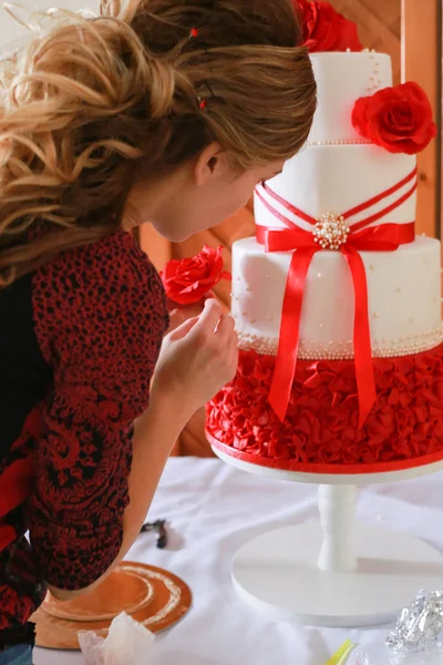 Konditor dekoriert Hochzeitstorte mit Marzipanblüten — Stockfoto