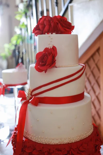 Weiße 4-teilige Hochzeitstorte mit roter essbarer Marzipanblume — Stockfoto