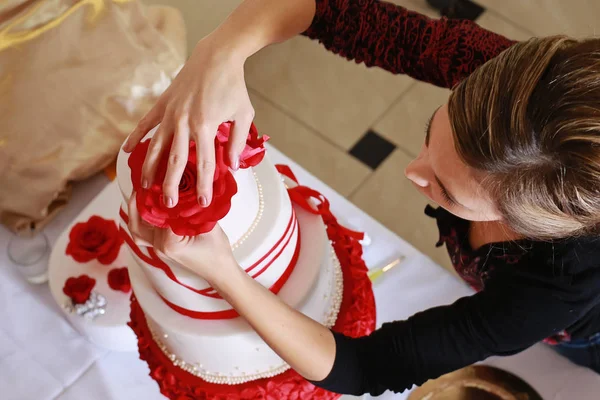 Кондитер украшает свадебный торт марципановыми цветами Лицензионные Стоковые Изображения