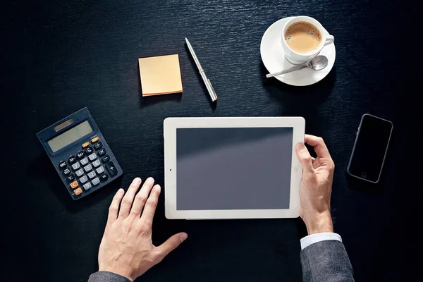 tablet, telefon, hesap makinesi, bir siyah tahta masada adam eller iş görüntülemek yukarıdan
