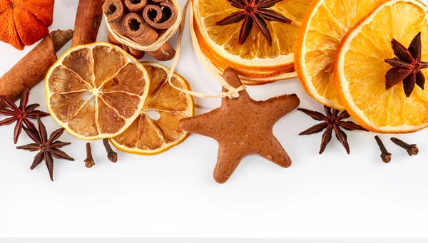 border of dried oranges, lemons, mandarins, star anise, cinnamon sticks and gingerbread, isolated on white background