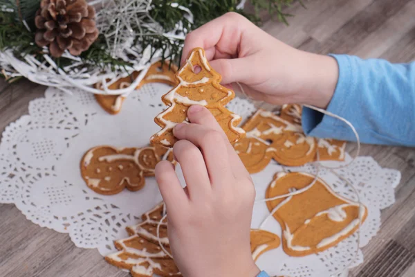 あけましておめでとうございます、幸せな家族の概念。子供のクローズ アップのジンジャーブレッドのクッキーからクリスマス ツリーの飾りを作るします。子供とベーキング — ストック写真