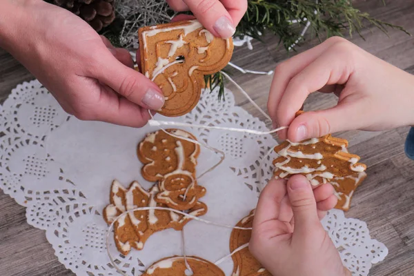 Nieuwjaar en gelukkige familie concept. Moeder en kind maken maken kerstboom decoratie van peperkoek cookie close-up. Bakken met kinderen — Stockfoto