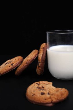 Çikolatalı kurabiye ve süt siyah arka plan üzerine