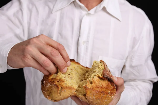 Hornear pan, Hombre comiendo sabroso pan fresco sin gluten de grano entero —  Fotos de Stock
