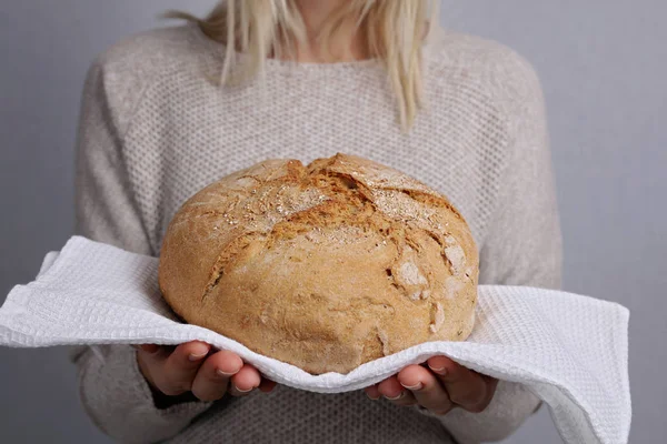 Bread baking, woman holding loaf of tasty fresh bread
