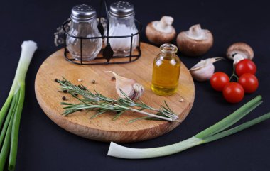 Yemek, sağlıklı beslenme kavramı. Zeytinyağı, otlar, baharatlar, mantar. Siyah arka plan üzerine taze, çiğ, organik sebze.