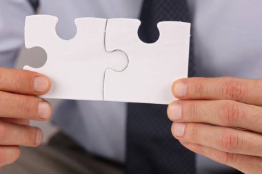 İş çözümleri, ortaklık kavramı. İki adet boş bir bulmaca tutan işadamı