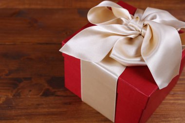 Ahşap arka plan üzerinde kırmızı mevcut kutu kurdele ile. Hediyelik kutu ambalaj. Doğum günü, yılbaşı, Sevgililer günü, 8 Mart, Noel kavramı, kopya alanı