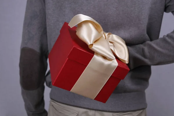 Man hiding a resent gift box behind his back close up. Love, Birthday, New year, Valentine's Day, 8 march, Christmas concept. — Stock Photo, Image